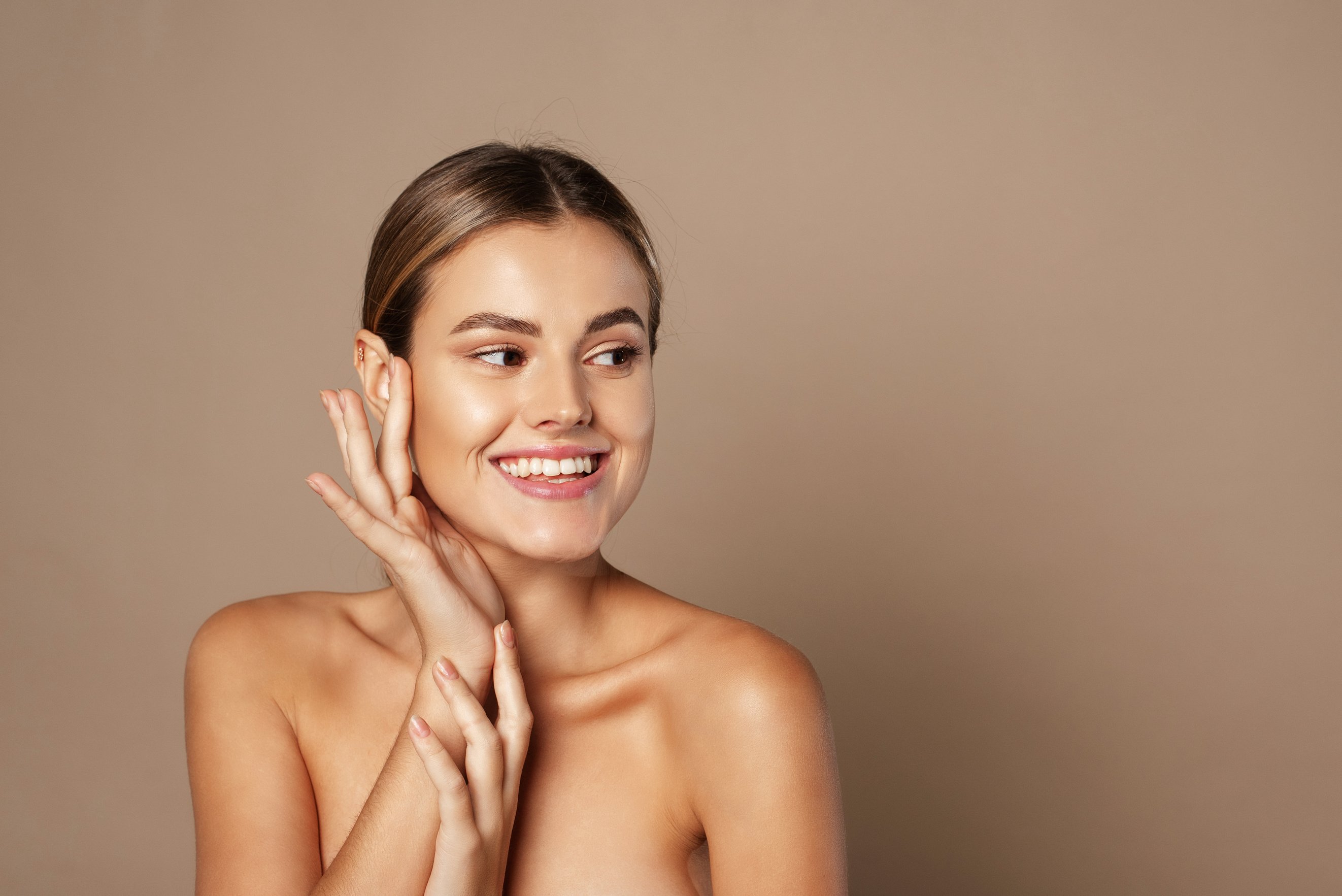 Smiling Female Model with Natural Makeup Touching Face